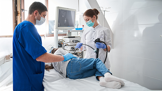 Female doctor holding endoscope while making gastroscopy for the little girl